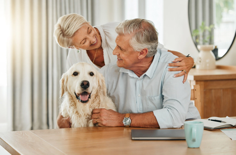 older couple and dog at table in home